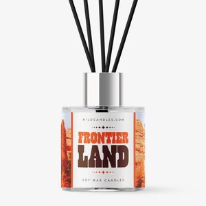 May include: A clear glass diffuser bottle with black reeds and a label that says "Frontier Land" in brown text on a red, orange, and yellow background. The label also says "Soy Wax Candles" and "MiloCandles.com".