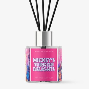 May include: A pink and blue diffuser bottle with a silver cap and black diffuser sticks. The bottle has a label that says "Mickey's Turkish Delights Soy Wax Candles".