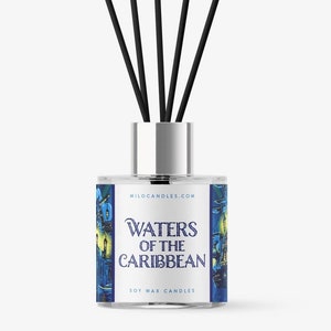 May include: A clear glass reed diffuser with a silver collar and black reeds. The label features the text "Waters of the Caribbean" with a blue and yellow illustration of a pirate ship and buildings. The product is from Milo Candles.