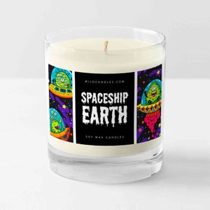 May include: A glass candle jar containing a white soy wax candle. The jar features a colourful label with the text "Spaceship Earth" and a graphic of cartoon spaceships and aliens. The label also includes the text "Soy Wax Candles" and the website "MiloCandles.com".