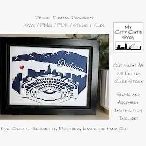 May include: A framed paper cut-out design of Dodger Stadium in Los Angeles, California. The stadium is in white with a blue background. The words "Dodgers" are in white lettering on the blue background. The design is for Cricut, Silhouette, Brother, laser or hand cut.