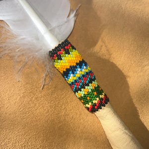 An Imitation Eagle Feather with beaded quill and fringe