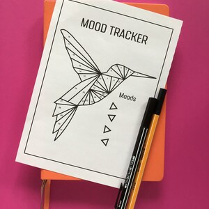 K&ouml;nnte beinhalten: Ein schwarz-wei&szlig;er druckbarer Stimmungs-Tracker mit einem Kolibri-Design. Der Tracker ist mit "Mood Tracker" beschriftet und hat die Zahlen 1 bis 31 auf den Fl&uuml;geln des Kolibris. Das Wort "Moods" steht unter dem Kolibri.