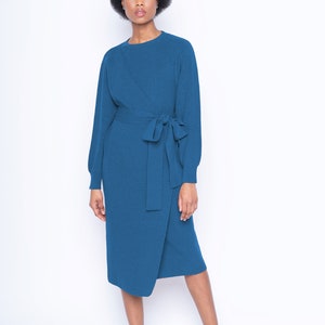 May include: A teal blue wrap dress with long sleeves and a self-tie belt. The dress is made of a soft, knitted fabric.