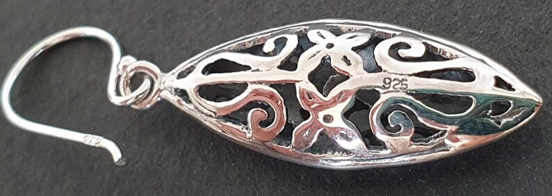 May include: Silver earring with a delicate, openwork design featuring a floral motif. The earring is marked "925" indicating it is made of sterling silver.