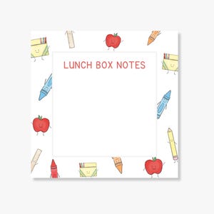 May include: A square notepad with a white center and a border featuring cartoon illustrations of red apples, yellow pencil boxes, blue and orange crayons, and rulers. The text LUNCH BOX NOTES is printed in red at the top of the white center area.