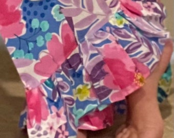 May include: A pair of floral print trousers with a ruffled hem. The trousers are made from a soft, lightweight fabric and have a comfortable fit.