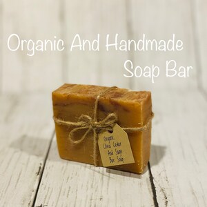 Pu&ograve; includere: Una saponetta biologica al cedro e salvia, avvolta in spago con un'etichetta di carta marrone su cui &egrave; scritto "Organic Citrus Cedar And Sage Bar Soap".