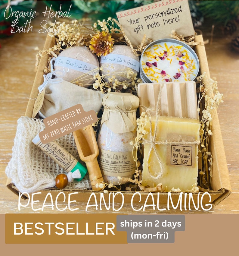 May include: A gift basket filled with bath products, including bath bombs, bath salts, soap, and a candle. The basket is made of brown cardboard and has a white label that says "Peace and Calming." The basket is surrounded by dried flowers and greenery.