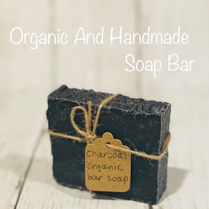 Pu&ograve; includere: Un sapone organico al carbone di legna nero, legato con uno spago e un'etichetta di carta marrone su cui &egrave; scritto "charcoal organic bar soap".