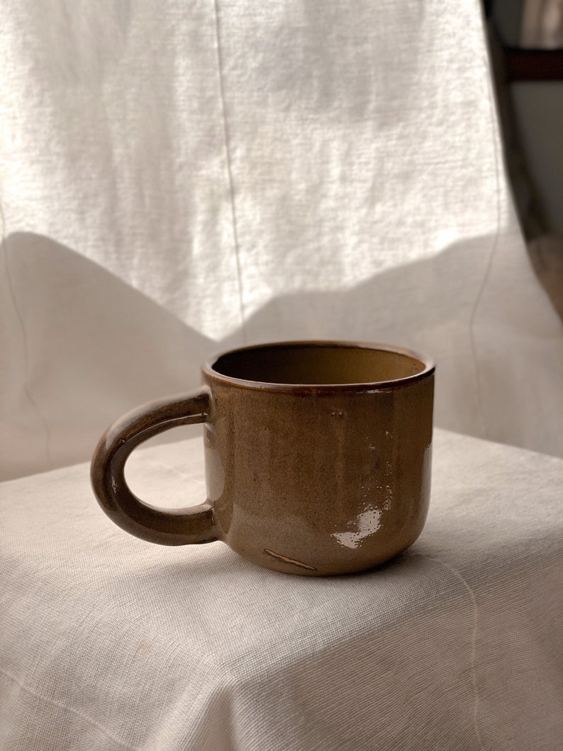 handmade ceramic mug in rust green/brown coloured glaze. Made image 1