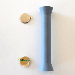 May include: Two round adhesive backed metal discs and a light blue plastic tube.