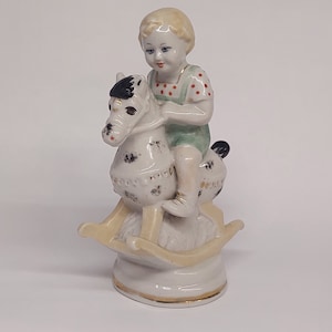 vintage porcelain figurine of a boy on a horse full of LCD