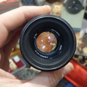 Pode incluir: Uma lente de câmera preta com o texto "FEIINGOC-42" e "63 17 9264" impresso na lateral.