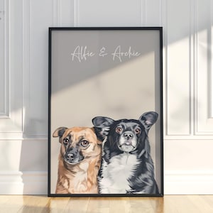 May include: Framed portrait featuring two dogs, one brown and tan, the other black and white. The artwork is set against a neutral background with the names "Alfie & Archie" in script. The frame is black, and the artwork is leaning against a wall.