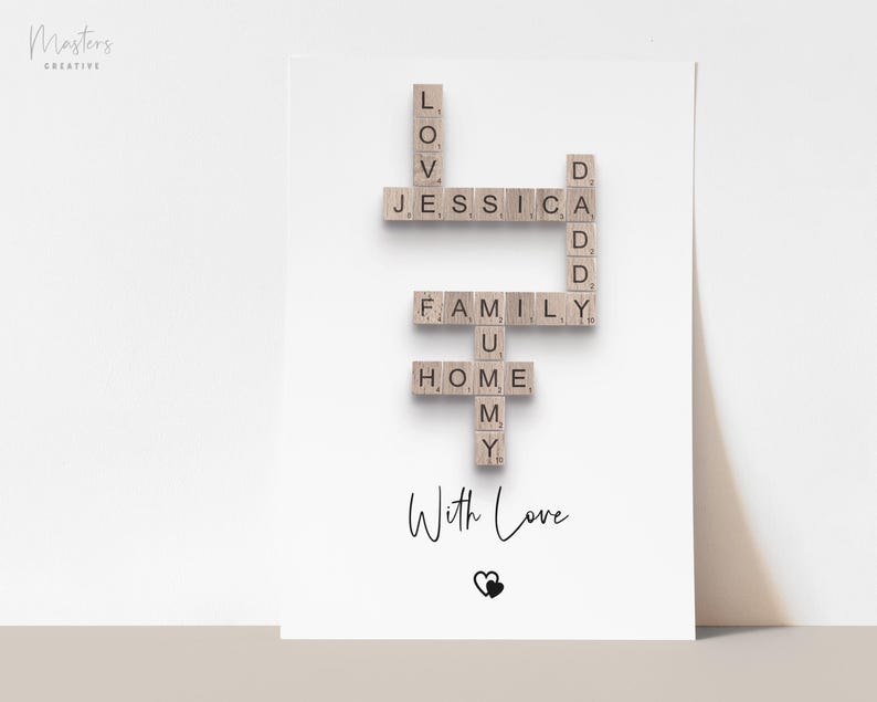 May include: A white rectangular print featuring a crossword-style arrangement of wooden letter tiles spelling LOVE, JESSICA, DADDY, FAMILY, MUMMY, and HOME. Below the tiles, the text With Love is printed in black script above a small heart icon.