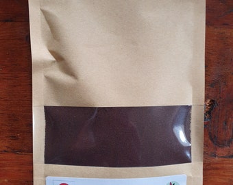 May include: A brown paper packet with a clear window showing a dark brown powder, labelled "Cuttack Silver." The packet has a white label with text about natural plant dyes and extracts, and a warning to wear gloves and a mask. The packet contains 50g of product.