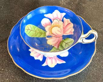 Delikatny zestaw filiżanek i spodków do herbaty Merit w stylu vintage, wyprodukowany w „okupowanej Japonii” z wyrazistym niebieskim szkliwem i ręcznie malowanymi różowymi kwiatami magnolii