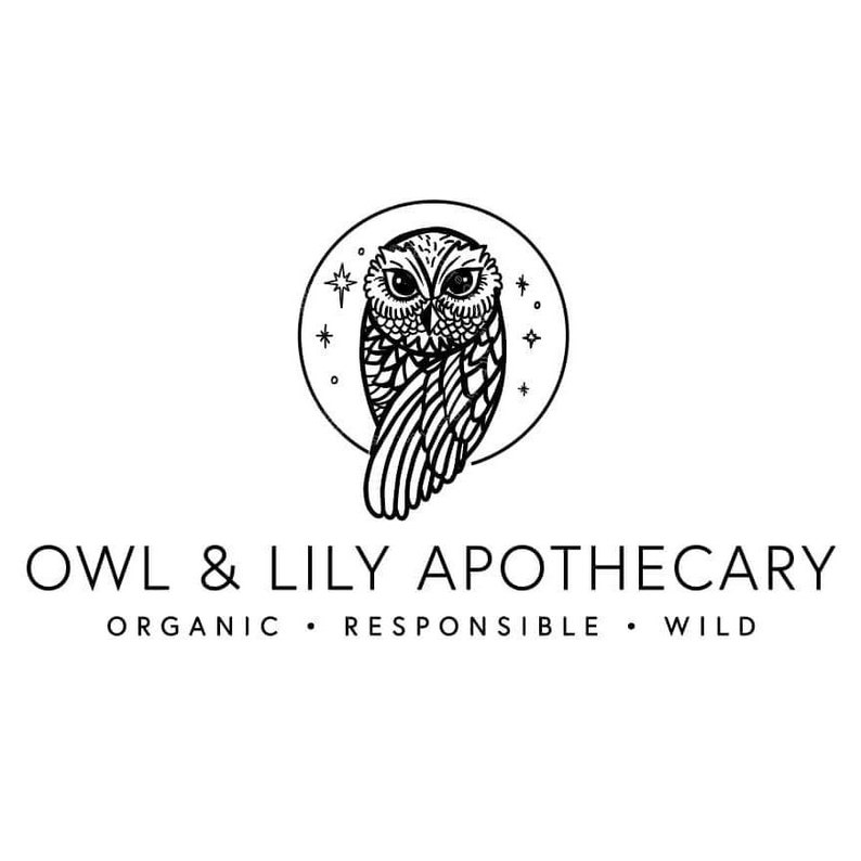 May include: Black and white logo for Owl & Lily Apothecary. The logo features a stylized owl with its wings spread, inside a circle with stars. The text "Owl & Lily Apothecary" is below the owl, with the words "Organic, Responsible, Wild" below the text.