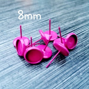 May include: Eight 8mm pink round earring settings with posts. The settings are made of metal and have a shiny finish.