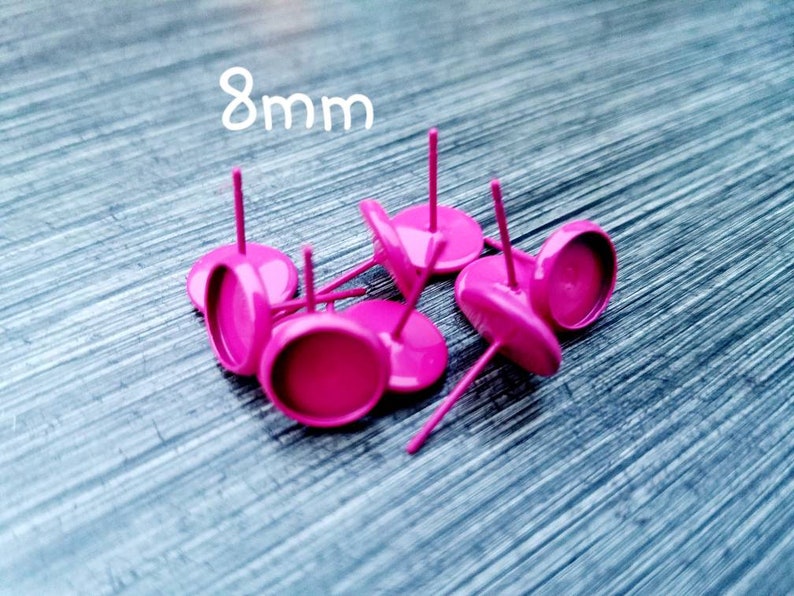 May include: Eight 8mm pink round earring settings with posts. The settings are made of metal and have a shiny finish.