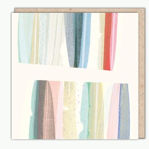 Puede incluir: Tarjeta de felicitación con un diseño abstracto. La tarjeta presenta dos formas rectangulares con rayas verticales en colores pastel, incluyendo rosa, azul, verde y amarillo. La tarjeta está sobre un fondo crema y dentro de un sobre marrón.