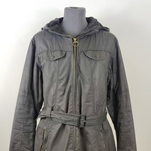 May include: A black hooded jacket with a belt and zipper closure. The jacket has two pockets on the chest and two pockets on the sides.