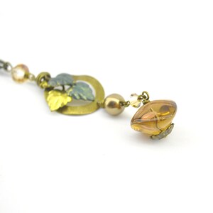 Necklace with charm mushroom and hazelnut and small vine leaf pendant and glass