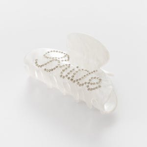 Add a touch of bridal sparkle to your special day with our pearlised diamanté “Bride” claw clip — the perfect accessory for any bride-to-be! Grab your girls and get hen party ready with our simply stunning, on trend, bride claw clip!