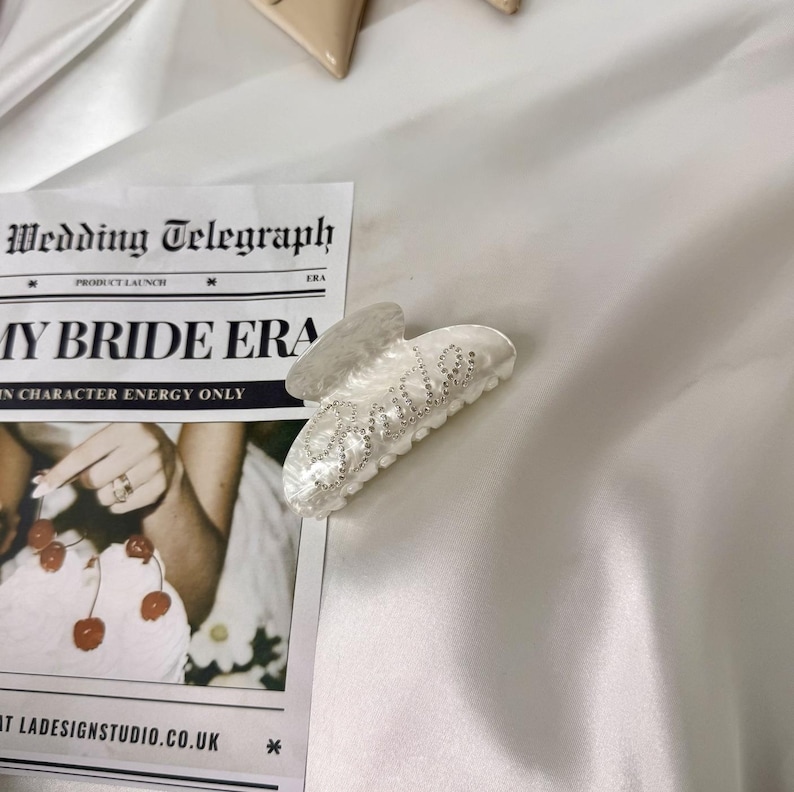 Add a touch of bridal sparkle to your special day with our pearlised diamanté “Bride” claw clip — the perfect accessory for any bride-to-be! Grab your girls and get hen party ready with our simply stunning, on trend, bride claw clip!