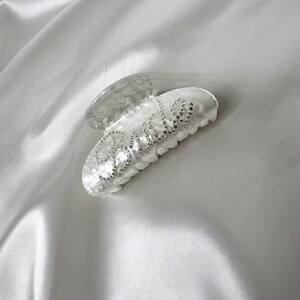 Add a touch of bridal sparkle to your special day with our pearlised diamanté “Bride” claw clip — the perfect accessory for any bride-to-be! Grab your girls and get hen party ready with our simply stunning, on trend, bride claw clip!
