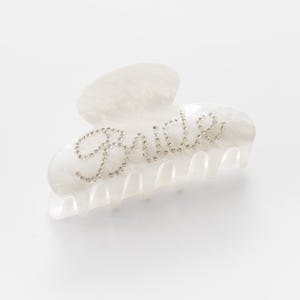 Add a touch of bridal sparkle to your special day with our pearlised diamanté “Bride” claw clip — the perfect accessory for any bride-to-be! Grab your girls and get hen party ready with our simply stunning, on trend, bride claw clip!