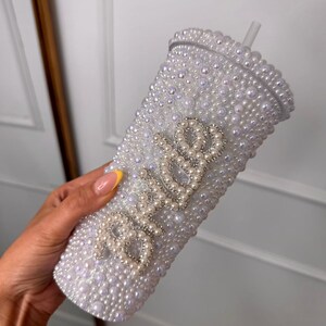 WOW! The ultimate cool-girl hen party accessory is here! Get hen party ready and prepare to sparkle with our dazzling BRIDE pearl stanley cup! Featuring a twist top, straw, pearl detailing and silver diamante bride text, this personalised cup is definitely one to make the bride stand out!