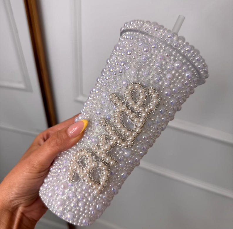 WOW! The ultimate cool-girl hen party accessory is here! Get hen party ready and prepare to sparkle with our dazzling BRIDE pearl stanley cup! Featuring a twist top, straw, pearl detailing and silver diamante bride text, this personalised cup is definitely one to make the bride stand out!