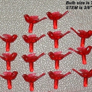 May include: A collection of small, red bird-shaped Christmas light bulbs. The text on the image indicates the bulb size is 7/16"H x 1-1/8"L, and the stem is 3/8"L x 3/16" Dia. These decorative bulbs are ideal for holiday decorating.