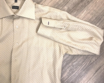 May include: Cream-colored button-down shirt with a subtle diagonal striped pattern. The shirt features a classic collar and buttoned cuffs. The Paul Smith label is visible on the collar.