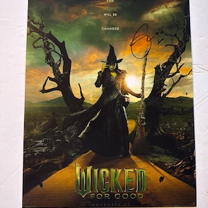 May include: A promotional poster for the musical "Wicked" featuring the Wicked Witch of the West. The poster has a green and gold color scheme with the words "Wicked For Good" and "November 21". The witch is holding a broom.