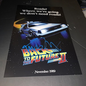 May include: A poster for the movie "Back to the Future Part II" featuring a DeLorean time machine. The poster has the text "Roads? Where we're going we don't need roads!" and "November 1989". The background is a starry night.