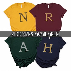 May include: Four short-sleeved t-shirts in mustard yellow, burgundy, dark green, and navy blue. Each shirt features a large letter: N, R, A, and H, respectively. The text "KIDS' SIZES AVAILABLE!" is displayed across the center of the image. These shirts are likely for children.