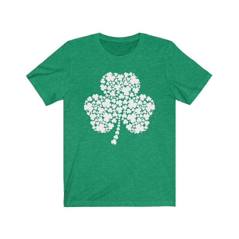 K&ouml;nnte beinhalten: Ein gr&uuml;nes T-Shirt mit einem wei&szlig;en Kleeblatt-Design, das aus kleineren Kleebl&auml;ttern besteht. Das Kleeblatt ist ein Symbol f&uuml;r Gl&uuml;ck und wird oft mit Irland in Verbindung gebracht.