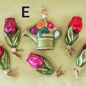 May include: Set of six glass ornaments featuring a green watering can with colorful flowers and five red and pink tulips. The ornaments have gold clips for hanging on a Christmas tree.