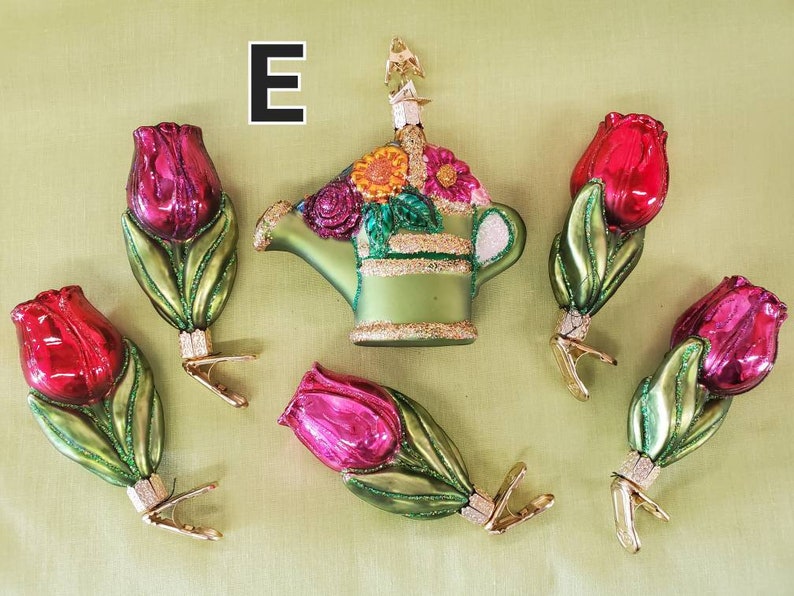 May include: Set of six glass ornaments featuring a green watering can with colorful flowers and five red and pink tulips. The ornaments have gold clips for hanging on a Christmas tree.