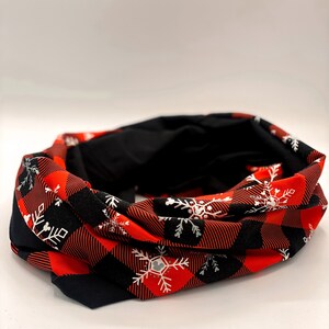 May include: Red and black buffalo plaid fabric neck warmer with white snowflake designs.
