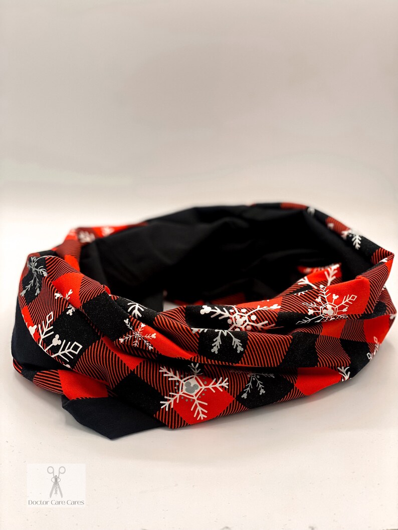 May include: Red and black buffalo plaid fabric neck warmer with white snowflake designs.