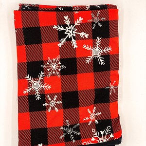May include: Red and black buffalo plaid fabric with white snowflakes and a Mickey Mouse silhouette in each snowflake.