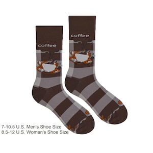 May include: A pair of brown socks featuring a coffee cup design. The socks have a plaid pattern in brown and grey. The word "coffee" is printed at the top of each sock. Suitable for shoe sizes 7-10.5.