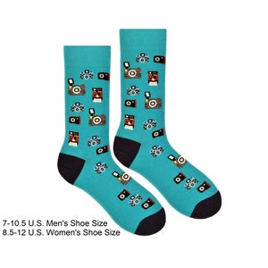 Peut inclure: Une paire de chaussettes bleu turquoise avec un motif d'appareils photo vintage. Les chaussettes ont un revers et une pointe noirs. Pointures hommes 7-10,5 US Pointures femmes 8,5-12 US