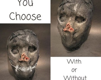May include: Two fabric masks, one with a stitched-on smile and one without. The masks are gray and have a distressed look. The text "You Choose" and "With or Without Smile" is visible in the image.