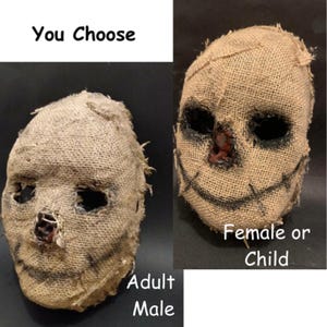Puede incluir: Dos m&aacute;scaras de arpillera con detalles cosidos y agujeros oscuros para los ojos. Una m&aacute;scara est&aacute; etiquetada como "Adult Male" y la otra como "Female or Child". El texto "You Choose" est&aacute; en la parte superior. Las m&aacute;scaras son probablemente para Halloween o disfraces.