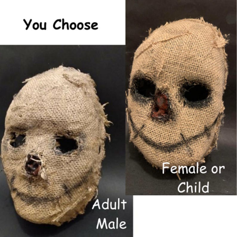 Puede incluir: Dos m&aacute;scaras de arpillera con detalles cosidos y agujeros oscuros para los ojos. Una m&aacute;scara est&aacute; etiquetada como "Adult Male" y la otra como "Female or Child". El texto "You Choose" est&aacute; en la parte superior. Las m&aacute;scaras son probablemente para Halloween o disfraces.
